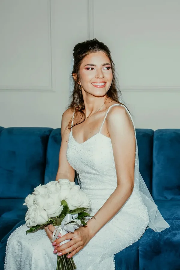 Mlada na plavom kauču sa buketom – fotograf Niš